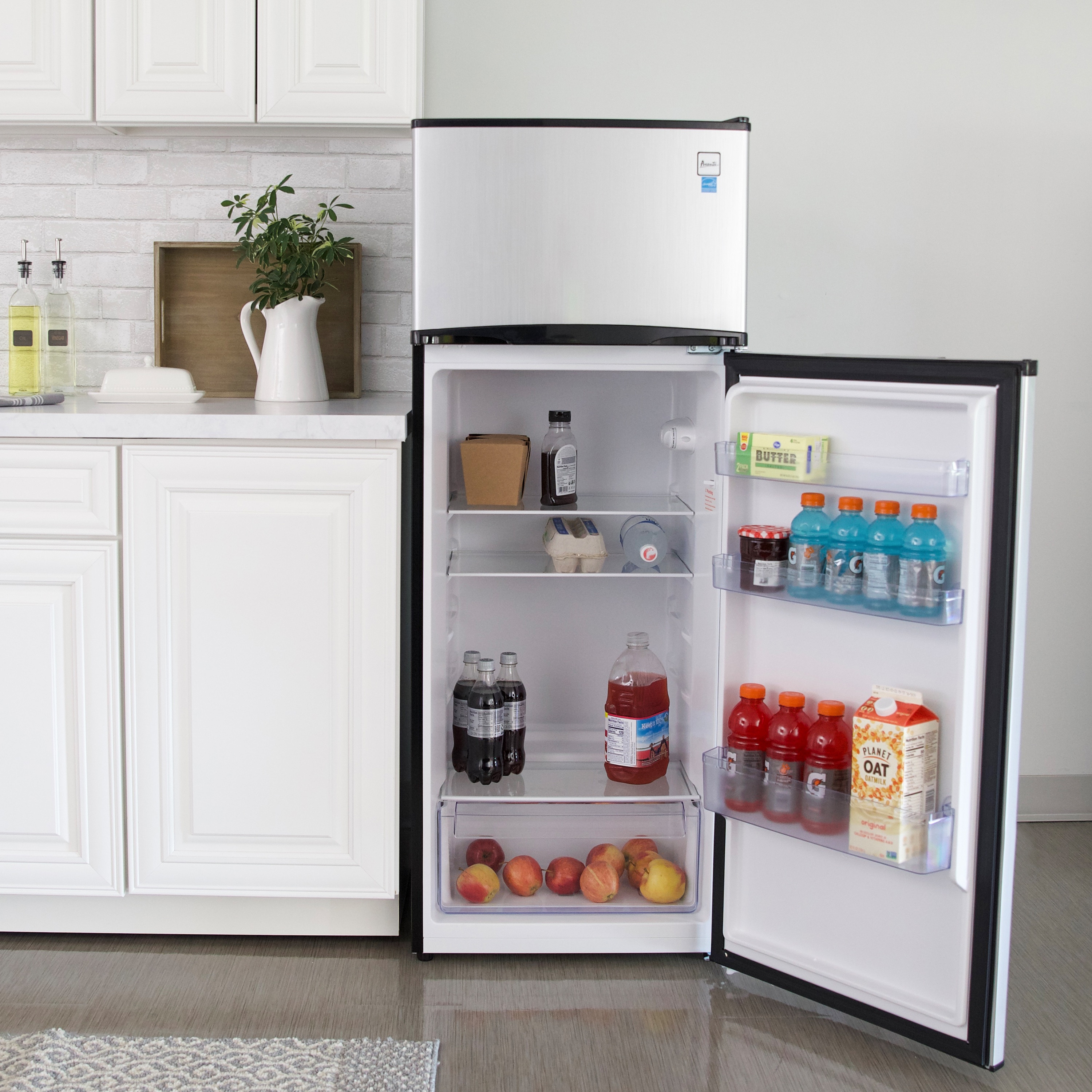 Avanti Refrigerator model RA733B3S, front-facing lifestyle kitchen view next to cabinetry, door open showing fully stocked interior 