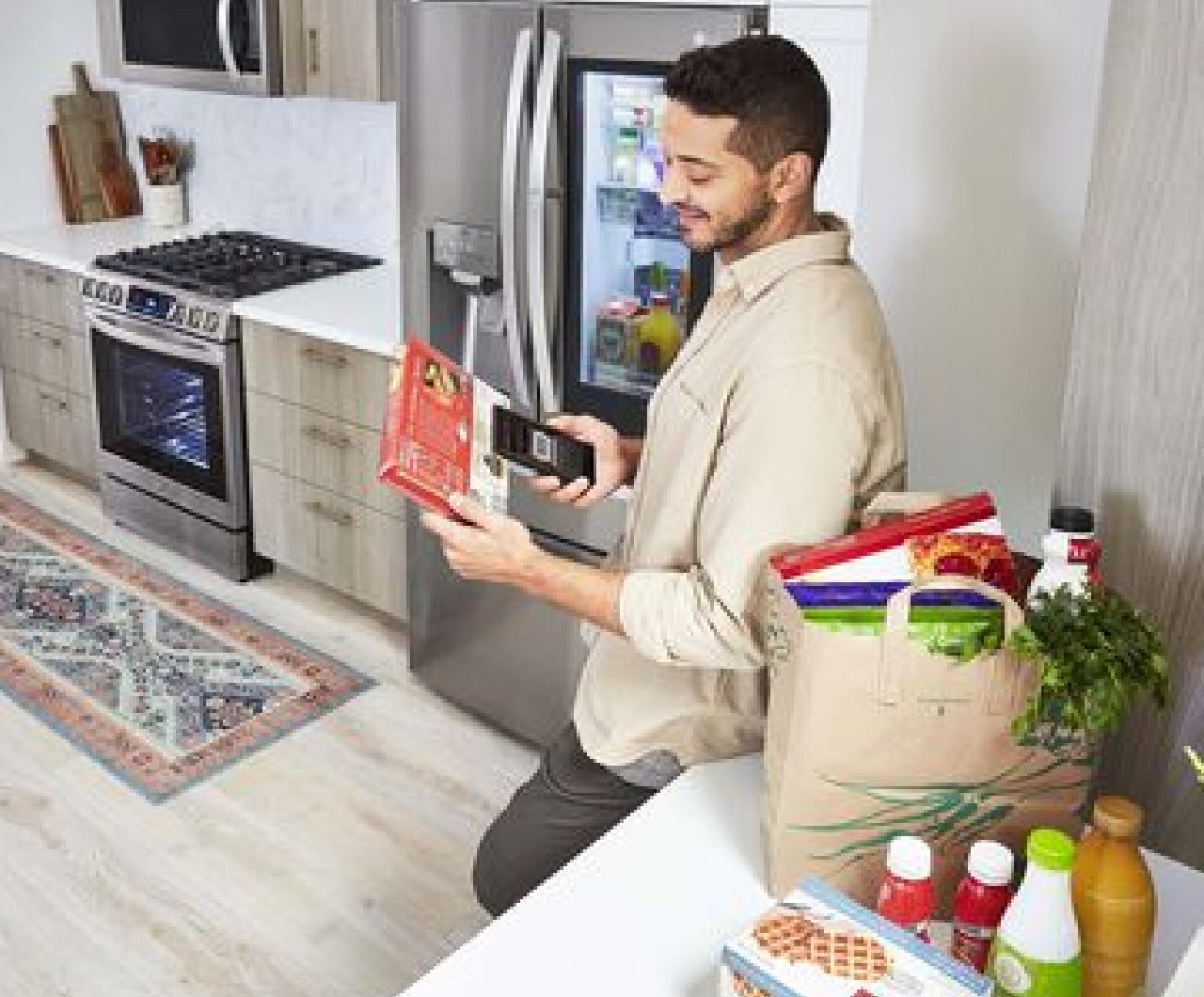 LG range model LSGL6335F, man using his mobile phone to access smart features affiliated with the appliance