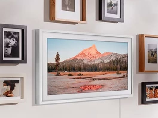 A wall full of framed images and a frame TV.